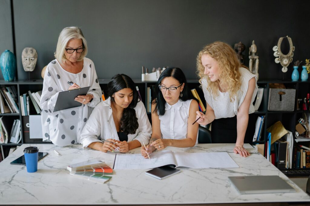 A group of women engaged in collaborative work at a modern office desk.